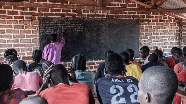 Des élèves lisant un texte écrit au tableau par leur enseignant, au sein du plus grand camp de déplacés en République centrafricaine, à Bria, le 26 avril 2023.