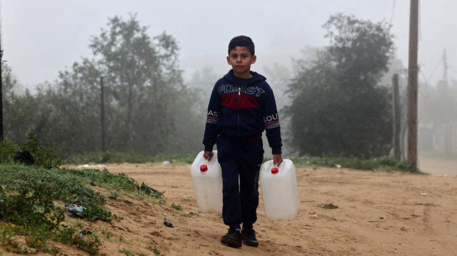 Un enfant Palestinien en manque d'eau à cause des bombardements de l'armée d'occupation israélienne, porte des jerricans vides pour aller chercher de l'eau à Rafah, dans le sud de la bande de Gaza, le 9 février 2024.