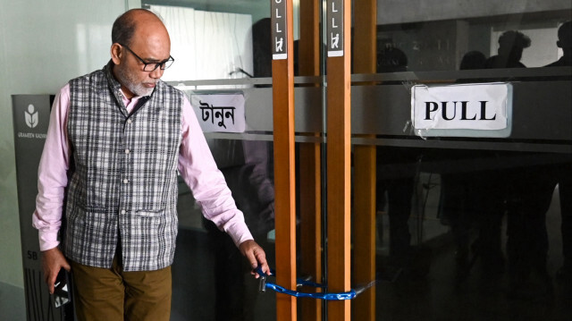 Lauréat du prix Nobel de la paix du Bangladesh Muhammad Yunus, montre un cadenas mis sur les portes du bureau de Dhaka le 15 février 2024. 