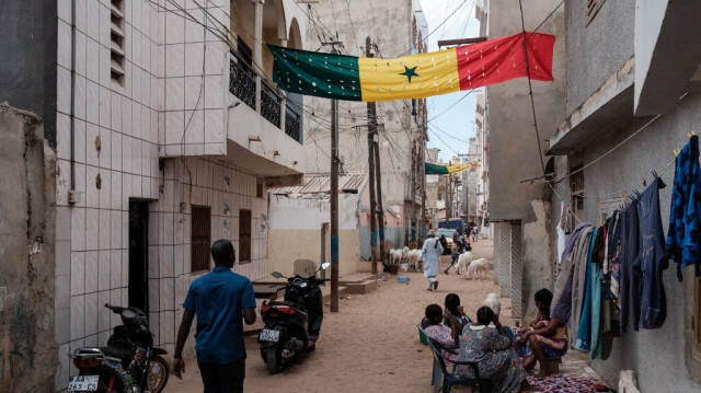 Un grand drapeau sénégalais est suspendu dans une rue d'un quartier de Dakar, le 13 février 2024.