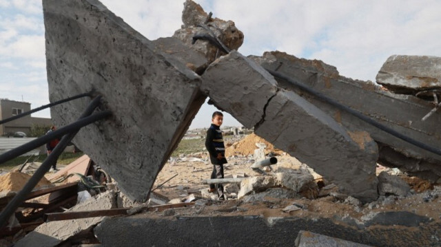 Un enfant palestinien passe devant une maison détruite à Rafah le 18 février 2024.