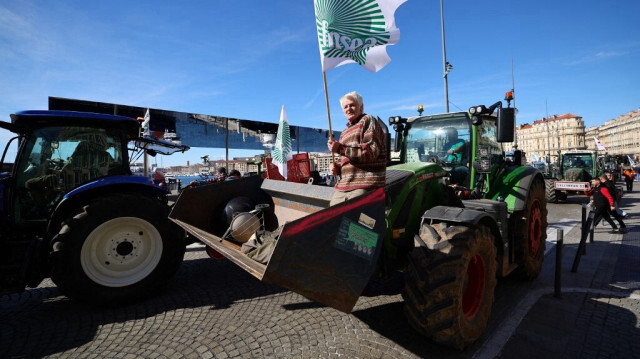 Un protestataire brandit le drapeau du syndicat agricole français FNSEA (Fédération Nationale des Syndicats d'Exploitants Agricoles) sur le Vieux Port, lors d'une manifestation d'agriculteurs français contre les politiques agricoles, à Marseille, en France, le 19 février 2024.