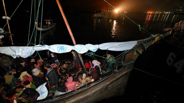 Les réfugiés rohingyas sont assis sur un bateau en bois après avoir été secourus par la marine indonésienne dans les eaux au large de Bireuen, à leur arrivée au port de Krueng Geukueh à Lhokseumawe, sur la côte nord de la province d'Aceh, le 31 décembre 2021.