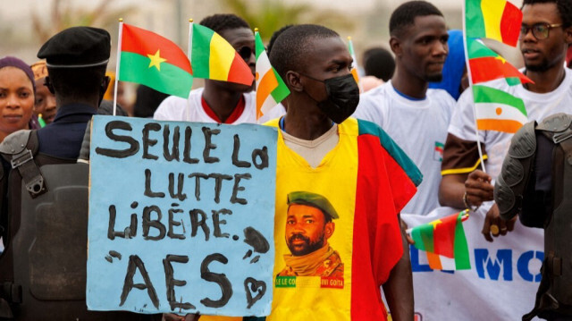 Un partisan de l'AES tient une pancarte avec l'inscription "seule la lutte libère" lors d'un rassemblement pour célébrer le retrait du Mali, du Burkina Faso et du Niger quittant la CEDEAO, à Bamako le 1er février 2024.