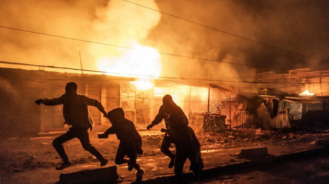 Des personnes courent pour se mettre à l'abri après une série d'explosions dans le quartier d'Embakasi à Nairobi, le 2 février 2024. 