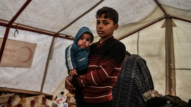 Mohammed El-Yazici, un Palestinien de 14 ans qui a perdu sa mère et n'a pas eu de nouvelles de son père en raison des attaques israéliennes, vit avec son petit frère de 6 mois à l'intérieur de la tente de fortune où ils s'abritent à Rafah dans Gaza, le 28 janvier 2024.