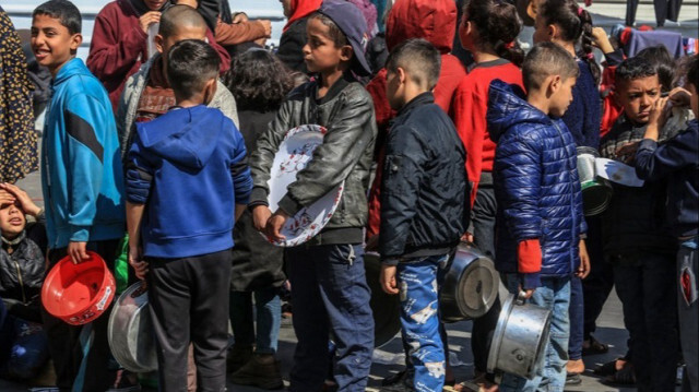 Des enfants palestiniens, font la queue pour recevoir un repas chaud préparé par des bénévoles dans la bande de Gaza, le 20 février 2024. 