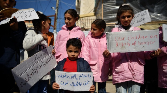 Des enfants palestiniens qui ont fui leurs maisons et se sont réfugiés à Rafah manifestent pour soutenir leurs camarades, qui souffrent de pénuries alimentaires, dans la partie nord de la bande qui est soumise aux attaques israéliennes à Gaza, le 21 février 2024.