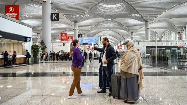 Un membre du personnel donne des informations aux passagers dans un hall de "l'aéroport d'Istanbul" .