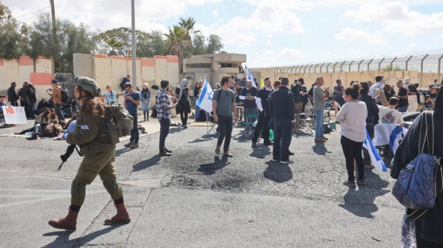 Des soldats de l'armée israélienne montent la garde près de la barrière frontalière avec l'Égypte au poste frontière de Nitzana, dans le sud d'Israël, le 18 février 2024, alors que des manifestants israéliens empêchent les camions d'aide humanitaire d'entrer dans la bande de Gaza.