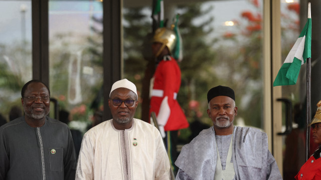 Le vice-président de la Gambie, Muhammad B. S. Jallow (M), reçu par le président de la Commission de la Communauté économique des États de l'Afrique de l'Ouest (CEDEAO), Omar Touray (G), et le ministre nigérian des Affaires étrangères, Yussuf Tuggar (D), lors de la session extraordinaire des chefs d'État et de gouvernement de la Communauté économique des États de l'Afrique de l'Ouest (CEDEAO) à Abuja, au Nigeria, le 24 février 2024. 