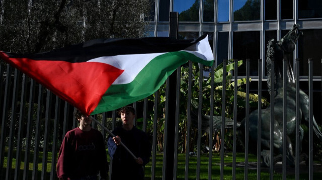 Des partisans brandissent le drapeau palestinien alors qu'ils participent à une "manifestation pour la Palestine" devant le siège de la télévision nationale italienne RAI, dans le centre de Rome, le 17 février 2024.