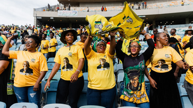 Des supporters portant des t-shirts à l'effigie du président sud-africain Cyril Ramaphosa chantant et dansant lors du lancement du manifeste électoral du Congrès national africain (ANC) au stade Moses Mabhida de Durban, le 24 février 2024.