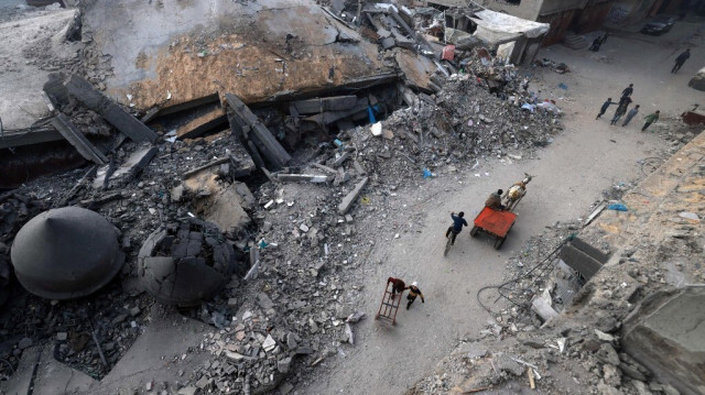 Une voiture tirée par un âne passe devant la mosquée Al-Faruq, détruite par les bombardements israéliens à Rafah, dans le sud de la bande de Gaza, lors d'une journée brumeuse le 25 février 2024.