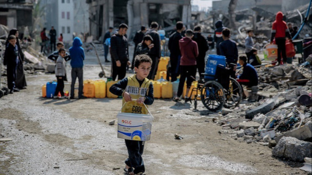 Des Palestiniens attendent avec des jerrycans vides pour les remplir d'eau propre, l'infrastructure ayant été fortement endommagée par les attaques israéliennes dans la ville de Gaza, le 25 février 2024.