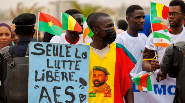 Un partisan de l'Alliance des États du Sahel (ASS) tient une pancarte sur laquelle on peut lire "seule la lutte libère" lors d'un rassemblement pour célébrer le départ du Mali, du Burkina Faso et du Niger de la Communauté économique des États de l'Afrique de l'Ouest (CEDEAO), à Bamako, le 1er février 2024. 