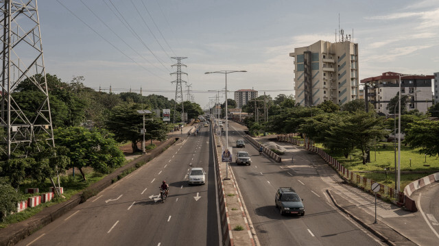 Des véhicules passent sur la route alors que la vie quotidienne se poursuit à Conakry, en Guinée, le 28 septembre 2023.