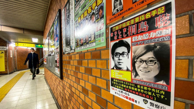 La photo en noir et blanc de Satoshi Kirishima au sourire juvénile, aux épaisses lunettes et aux cheveux longs était affichée depuis des décennies sur les murs des postes de police dans tout le Japon.