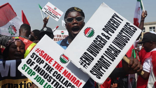 Un manifestant tient des pancartes lors d'une manifestation à Abuja le 27 février 2024. 