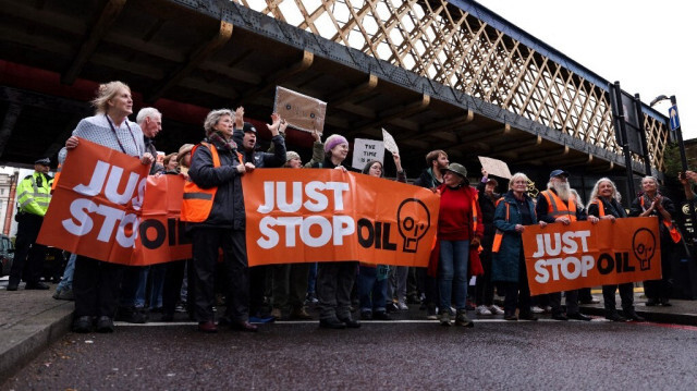 Les militants pour le climat de Just Stop Oil tiennent des pancartes lors d'une marche "People vs Oil!", à Londres, le 18 novembre 2023.