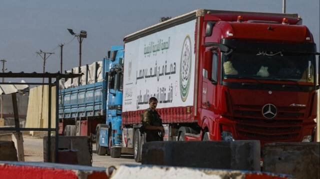 Un soldat de l'armée d'occupation israélienne à proximité d'un camion transportant de l'aide humanitaire du côté israélien, au point de passage frontalier de Kerem Shalom, situé au sud de la Bande de Gaza.