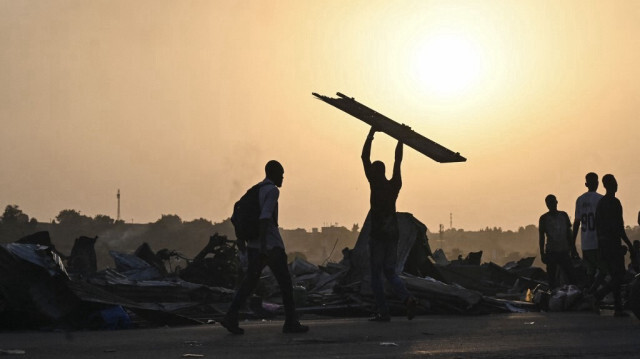 Des habitants expulsés se rassemblent dans la rue avec leurs biens dans le quartier de Boribana d'Attecoube à Abidjan, après la démolition de leurs maisons le 26 février 2024. 