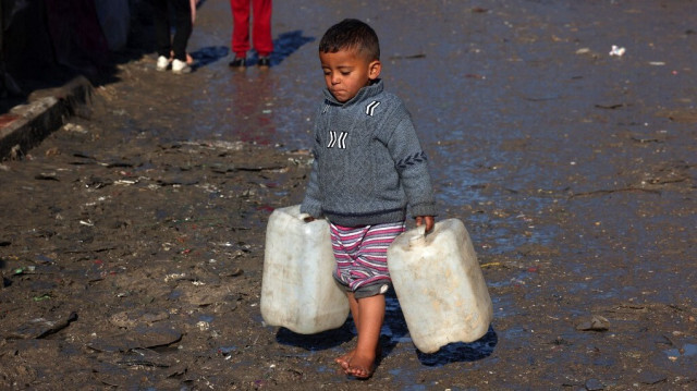 Un jeune garçon porte des jerricans vides à Rafah, dans le sud de la bande de Gaza, le 3 février 2024.