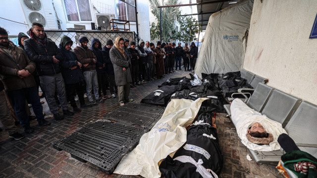 Des hommes récitant une prière près des corps des personnes tuées par les bombardements israéliens, à l'hôpital Najjar de Rafah, dans le sud de la bande de Gaza, le 3 février 2024.