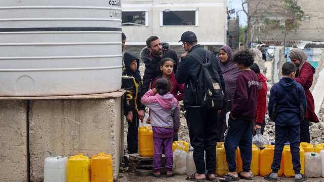 Des familles palestiniennes déplacées font la queue pour remplir des bidons en plastique à partir d'un réservoir d'eau à Rafah, dans le sud de la bande de Gaza, le 28 janvier 2024.