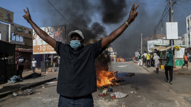 Un citoyen sénégalais réagit devant une barricade en feu lors des manifestations organisées par les partis de l'opposition à Dakar le 4 février 2024. 