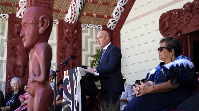 Le Premier ministre néo-zélandais Christopher Luxon (C) s'adressant aux Maoris locaux et à des invités sur le terrain du traité de Waitangi, à Waitangi le 5 février 2024.