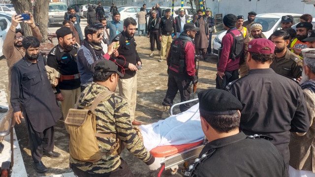 Les policiers déplacent le corps d'un collègue qui a été tué dans une attaque contre un poste de police, dans un hôpital de Dera Ismail Khan, le 5 février 2024.