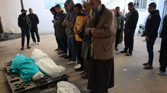 Des personnes récitant une prière sur le corps d'Alia Abu-Takia et d'autres personnes tuées lors d'un bombardement israélien nocturne, devant la morgue de l'hôpital Najjar à Rafah, dans le sud de la bande de Gaza, le 4 février 2024.