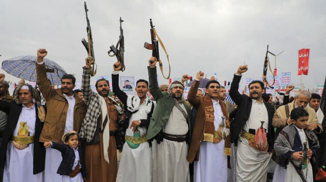 Des personnes brandissant des fusils et des pancartes lors d'un rassemblement anti-israélien et anti-américain à Sanaa, la capitale contrôlée par les Houthis, le 19 janvier 2024.