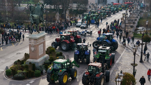 Des agriculteurs espagnols passent avec leurs tracteurs devant la statue d'El Cid Campeador lors d'une manifestation réclamant des conditions de travail équitables dans le secteur agricole, à Burgos, dans le nord de l'Espagne, le 6 février 2024.