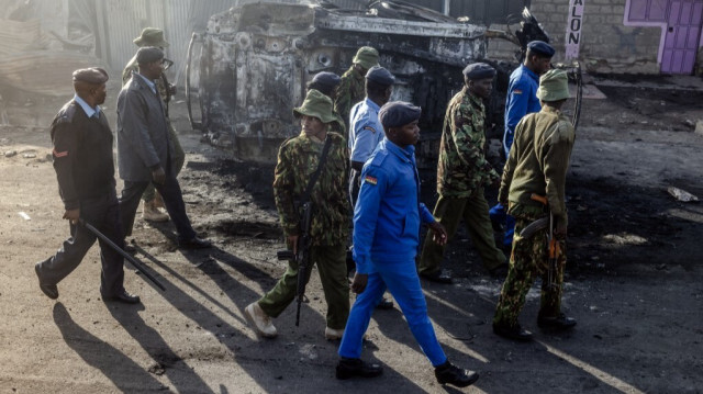 Des policiers kenyans passent devant des maisons et des magasins lourdement endommagés, un jour après une explosion de gaz dans le quartier d'Embakasi à Nairobi, le 2 février 2024. 