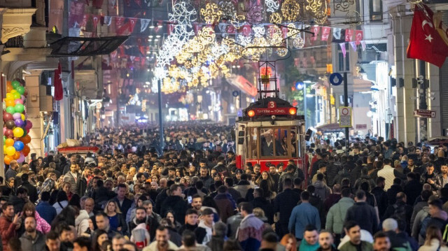 Des personnes passant devant un tramway historique sous des décorations lumineuses de Nouvel An dans la rue Istiklal pendant les préparatifs pour célébrer la nouvelle année 2024 à Istanbul le 31 décembre 2023.