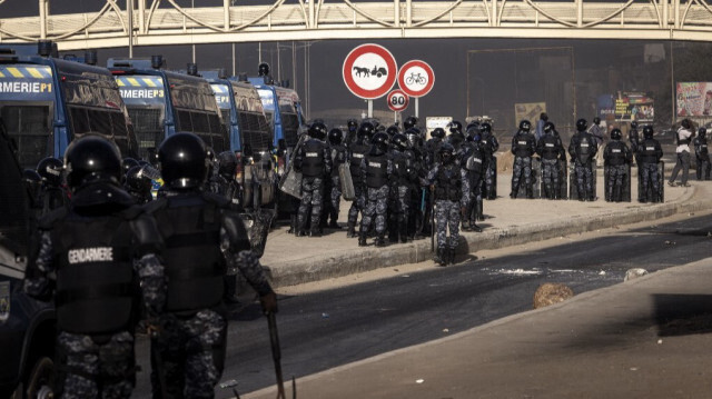 Des gendarmes sénégalais marchent dans une rue lors des manifestations appelées par les partis d'opposition à Dakar, le 4 février 2024, pour protester contre le report de l'élection présidentielle.