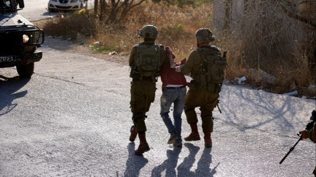 Des soldats israéliens arrêtent un Palestinien lors d'un raid en Palestine occupée.