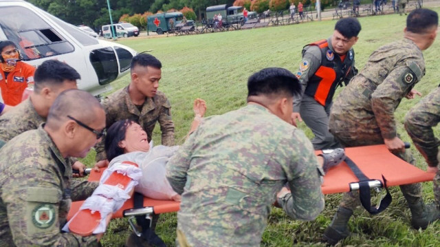 Le 60e bataillon "médiateur" d'infanterie de l'armée philippine montre des soldats philippins transférant un survivant de glissement de terrain d'un hélicoptère à une ambulance.