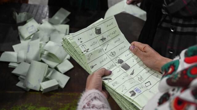 Les responsables électoraux comptent les bulletins de vote après la fermeture des bureaux de vote dans un bureau de vote lors de l'élection nationale pakistanaise à Lahore le 8 février 2024.