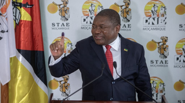 Le président du Mozambique, Felipe Nyusi, montre son doigt taché d'encre après avoir voté lors des élections locales de 2023 à Maputo, le 11 octobre 2023. 