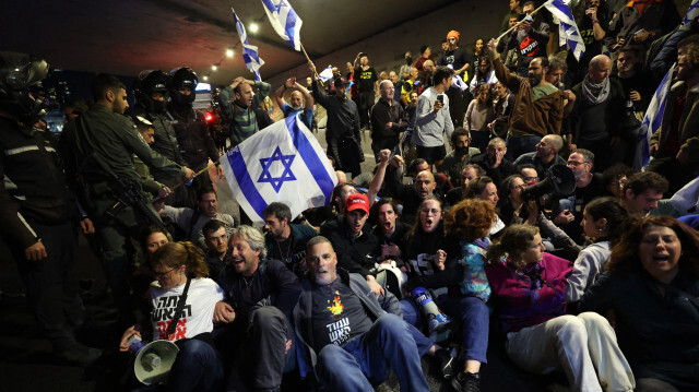 Des militants anti-gouvernementaux et des parents d'otages israéliens détenus à Gaza depuis les attaques du 7 octobre par des militants du Hamas, bloquant une route lors d'une manifestation à Tel Aviv le 9 mars 2024.