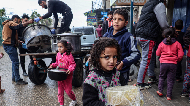 Des enfants palestiniens déplacés portant des rations de soupe de lentilles rouges, distribuées par des bénévoles à Rafah, dans le sud de la bande de Gaza, le 18 février 2024, dans le cadre du conflit actuel entre Israël et le groupe militant Hamas. L'UNICEF, l'agence des Nations Unies pour l'enfance, a prévenu que le manque alarmant de nourriture, la malnutrition galopante et les maladies pourraient conduire à une "explosion" du nombre de décès d'enfants dans la bande de Gaza. Un enfant sur six âgé de moins de deux ans à Gaza souffre de malnutrition aiguë, a estimé l'organisation le 19 février.