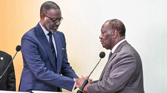 Le président ivoirien Alassane Ouattara (à droite) et le président du Parti démocratique de Côte d'Ivoire (PDCI) Tidjane Thiam (à gauche) se serrent la main lors d'une conférence de presse à l'issue d'une réunion au palais présidentiel d'Abidjan, le 11 mars 2024.