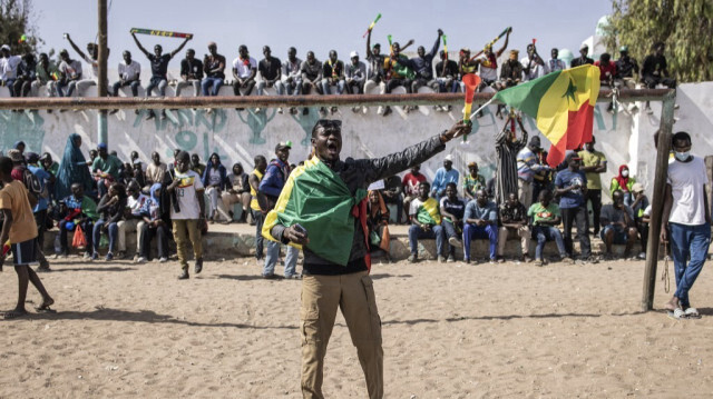 Un partisan de la coalition des candidats anti-système agite un drapeau sénégalais lors d'un rassemblement de campagne à Dakar, le 10 mars 2024.