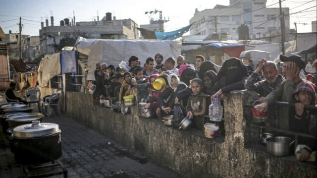 Des Palestiniens déplacés se regroupent pour recevoir de la nourriture distribuée par une organisation caritative à Rafah dans le sud de la Bande de Gaza, le 11 mars 2024.