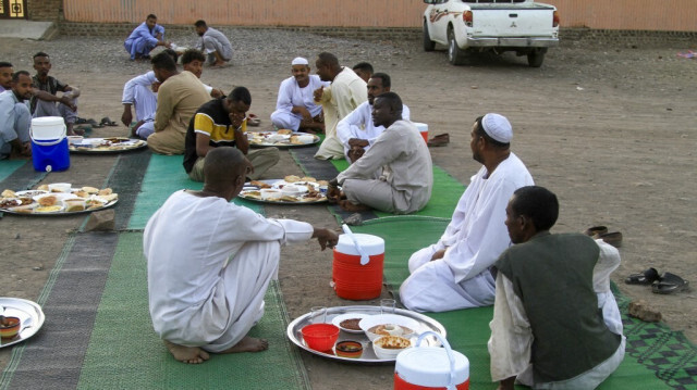 Des fidèles musulmans attendent de rompre leur jeûne dans une cour pendant le mois sacré du Ramadan à Gedaref, au Soudan, le 12 mars 2024.