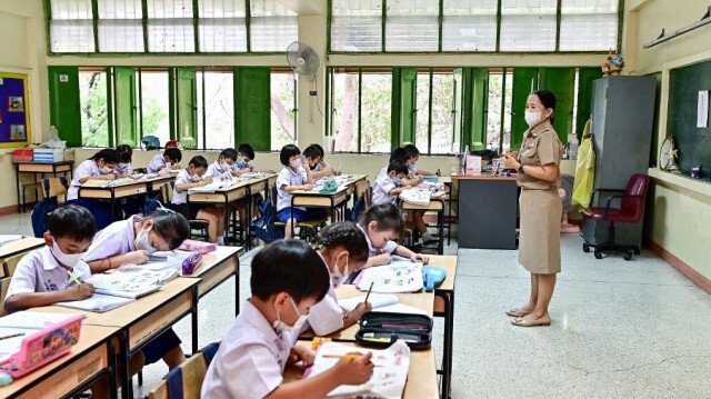 Des centaines d'enfants thaïlandais s'efforçant de chanter l'hymne national, des voix de roseaux et des poumons fragiles en compétition contre huit voies de circulation à côté de l'atrium ouvert de leur école dans le centre de Bangkok.