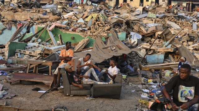 Des habitants expulsés se rassemblent dans la rue avec leurs biens dans le quartier Boribana d'Attecoube à Abidjan, après la démolition de leurs maisons le 26 février 2024. 